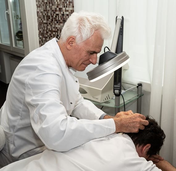 Haaranalyse vom Arzt durchgeführt Arzt analysiert die Haarsituation eines Patienten