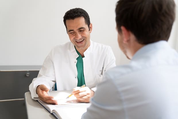 Arzt erklärt die Nachsorge Arzt bei der Beratung mit einem Patienten
