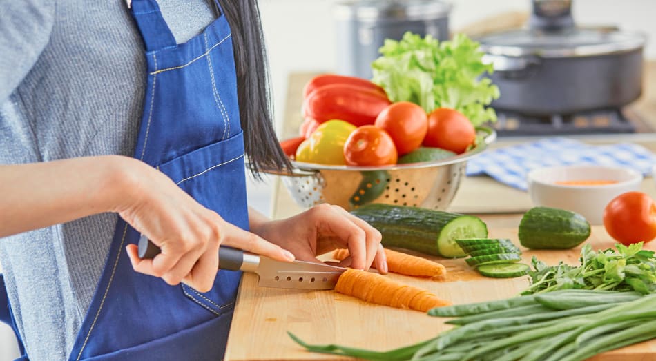 rau schneidet frisches Gemüse in der Küche