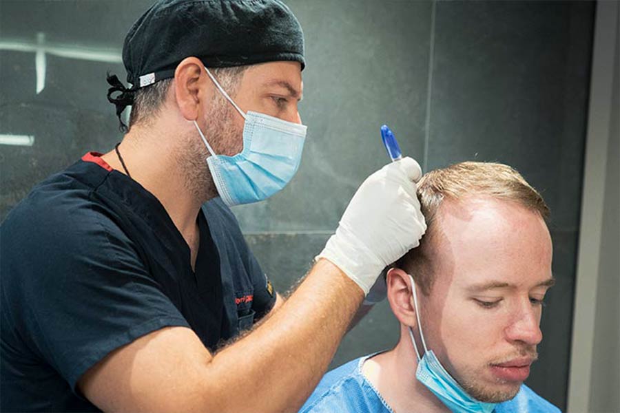 Spezialist der First Hair Clinic mit Patient, der seine Haarlücken füllen möchte mit einer Haartransplantation