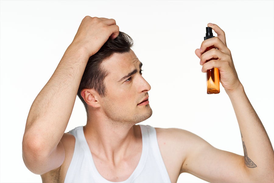 Mann möchte seine Haarlücken füllen mit Spray